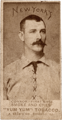 A mustachioed man with parted dark hair