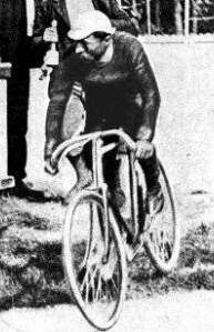 A man with a hat on a bicycle.