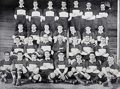 A group of rugby union players posing in several rows while wearing their uniforms