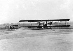 Two biplanes on a runway: a twin-engine in the foreground and a single-engine in the background