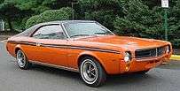 Shows a 1969 AMC Javelin featuring optional in Big Bad Orange paint and optional black vinyl covered roof and full length body side stripes