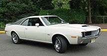 Shows a white 1970 AMC Javelin with optional black vinyl covered "halo" roof and "Go package"