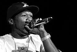 Black-and-white closeup of 50 Cent singing onstage