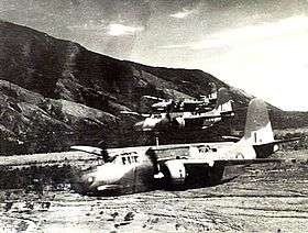 Three twin-engined military aircraft flying low above a valley
