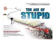A red timeline leads from the past into a ruined city scape. The film title "The Age of Stupid" is shown on the upper right in block capital blue writing