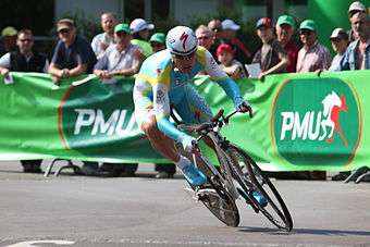 A cyclist riding a time trial while wearing a skinsuit.