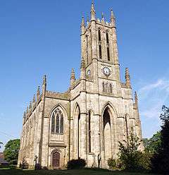 An elaborate Gothic Revival church with a west tower and crosketed pinnacles