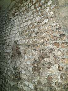 Vue d'un mur en petits moellons réguliers. Légende détaillée ci-dessous.
