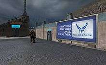 A billboard standing against a wall in a futuristic city during a rain shower. An armored man, about half its size, stands nearby looking at it. Billboard displays advertisement reading "Don't just play video games, inspire them. U.S. Air Force"