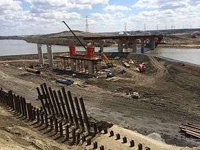 Berms were used for construction of two steel bridges carrying Anthony Henday Drive over the North Saskatchewan River in northeast Edmonton, first on the river's south bank, then the north bank seen here in 2014. The bridges carry three lanes northbound and four lanes southbound.