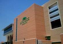 A large, contemporary structure with a light green logo that says "Apogee Stadium".