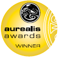A gold colored circle with the words "aurealis awards" across the middle, and "winner" situated in the lower portion. In the top portion is a smaller black and white circle with various curving lines and a shape of an eye in the middle