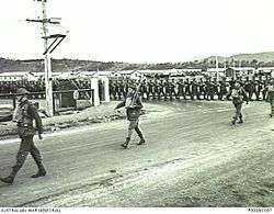 Soldiers march through the gates of a military barracks