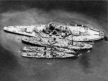 Aerial view of large ship and three smaller ones, side by side