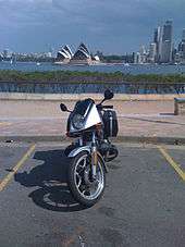 Front view of BMW R65LS motorcycle parked in a car park with the Sydney Opera House visible across the bay
