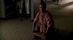 A man who is missing his legs rests on a wheeled cart.