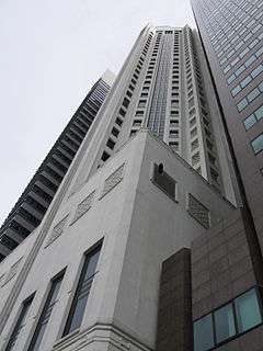 Ground-level view of a 40-storey white building with a square podium and star-shaped cross section