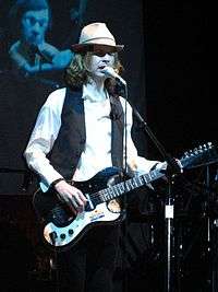 Beck playing the guitar during a concert.