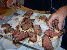 Diners reach for the beef tenderloin slices being proffered on a tray