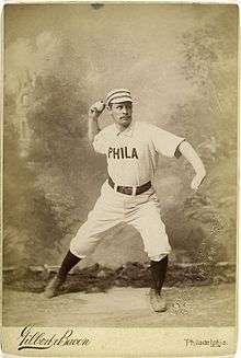 A baseball player is posing as if in the action of throwing a baseball.