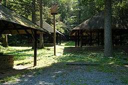 Three rustic picnic shelters in a forest