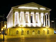 exterior of large neo-classical civic building, lit up at night