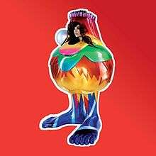 In the picture we can see in front of a red background, a king of metal sculpture with the shape of a "fat" bottle with feet, decorated with many colours and flowers, it has a big pearl in one of its sides, and it has a hole, which through we can see Björk's head.