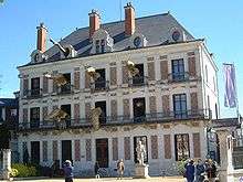 photo of the front of the mansion that houses the French magic museum, "La Maison de la Magie Robert-Houdin". Large figures of crocodiles and a snake seem to be coming out of the open windows.
