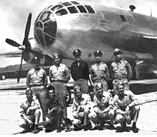 Formal picture of ten men in uniform. Five are standing and five are kneeling. In contrast to the Enola Gay picture, all are in correct uniform. The five standing are wearing ties, and all but one of the ten wears a peaked cap or garrison cap.