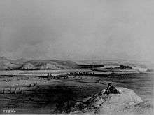 Painting of a fort surrounded by tepees on the bank of a river curving around a series of bluffs