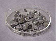 Several dozen small angular stone like shapes, grey with scattered silver flecks and highlights.
