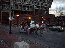 Horse-drawn carriage at dusk on a city street