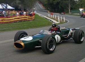 A green cigar-shaped racing car with exposed wheels and an open cockpit. The number one is painted on the nose and sides.