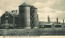 A large barn and silos