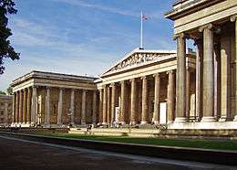 A museum building designed in the Greek Revival style with a flag on top.