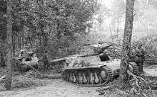 a black and white photograph of several tracked vehicles in a forest