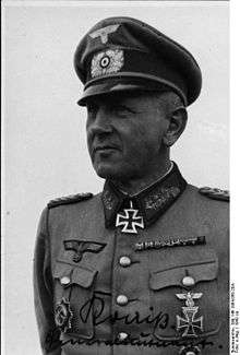 A man wearing a military uniform with an Iron Cross displayed at the front of his uniform collar.