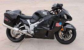 Side view of a modern sport motorcycle with enclosing bodywork, painted black with a US flag on the side, a decal in the shape of the state of Oklahoma, and the legends Highway Patrol and State Trooper