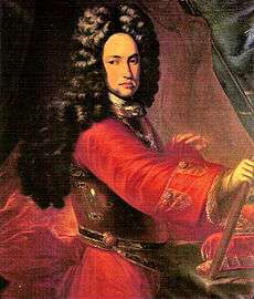 Man with long, dark curls and red tunic