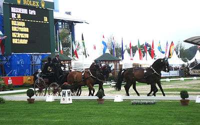 Carlo Macheroni, in top hat, driving four bay horses in a show
