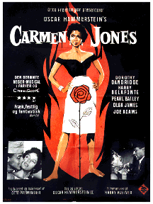 An image of a theatrical poster for the film Carmen Jones. The poster depicts Dorothy Dandridge, as Carmen Jones, standing provocatively in front of a flame.