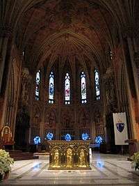 A closer view of the rear of the church interior seen above, with a golden altar in the foreground