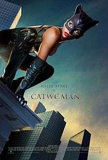 Movie poster that reads: "Halle Berry is Catwoman". In the foreground, Berry wears a leather suit and crouches on the edge of a tall building.