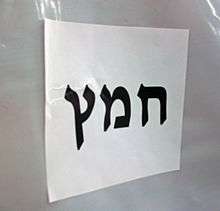 "Chametz" in large black Hebrew letters on a letter-size piece of paper, affixed horizontally to white plastic background.