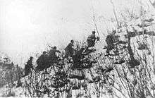 A group of soldiers climbing up a snow-covered hill