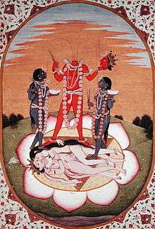 A decapitated, nude, red-complexioned woman stands on a copulating couple inside a large lotus. She holds her severed head and a scissor-like weapon. Three streams of blood from her neck feed her head and two nude, blue-coloured women holding a scissor-like object and a skull-cup, who flank her. All three stand above a copulating couple.