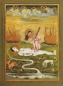 A nude, decapitated Chhinnamasta holds her severed head in her right hand and a sword in the left. She seats squatting on and in coitus with a white-complexioned naked Shiva lying on the ground. Cremation pyres appear in the background. Dogs and jackals feast on severed human heads in the foreground.