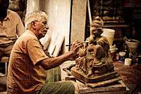 Man painting a statue of Ganesha