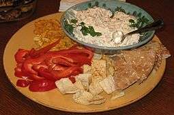 Chunky clam dip with various foods for dipping