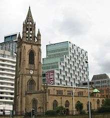 A church with an elaborate steeple on the left